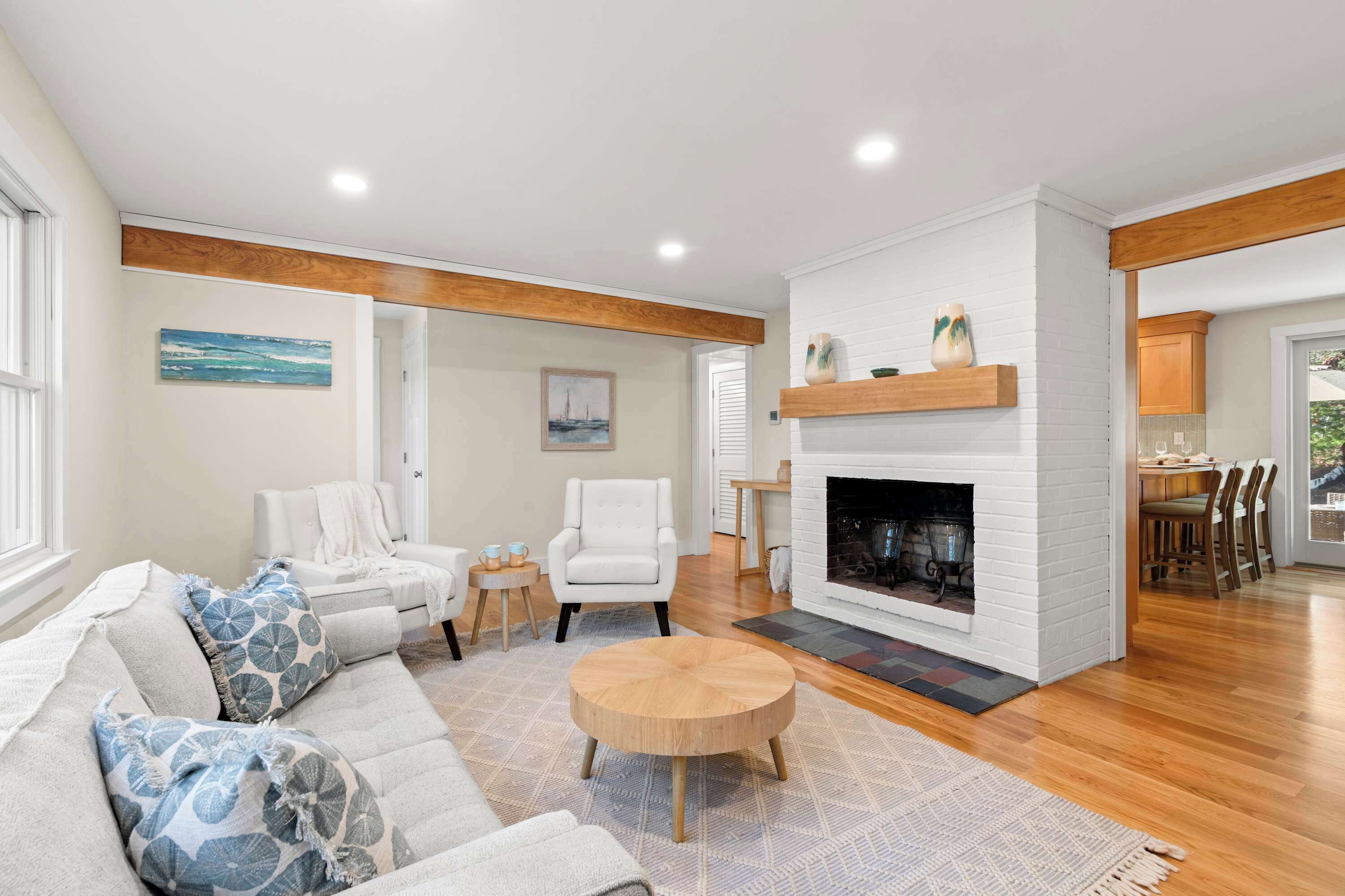 A spacious living room with a fireplace, a sofa set, and a dining area.