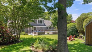 A house with a backyard, a wooden deck, and a swimming pool.