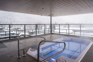 Un jacuzzi con vista a un paisaje nevado.
