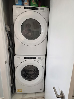 A laundry room with two stacked Whirlpool washing machines. - Furnished studio, all incl, pet-friendly, view, Landmark District, Kelowna. (Kelowna)