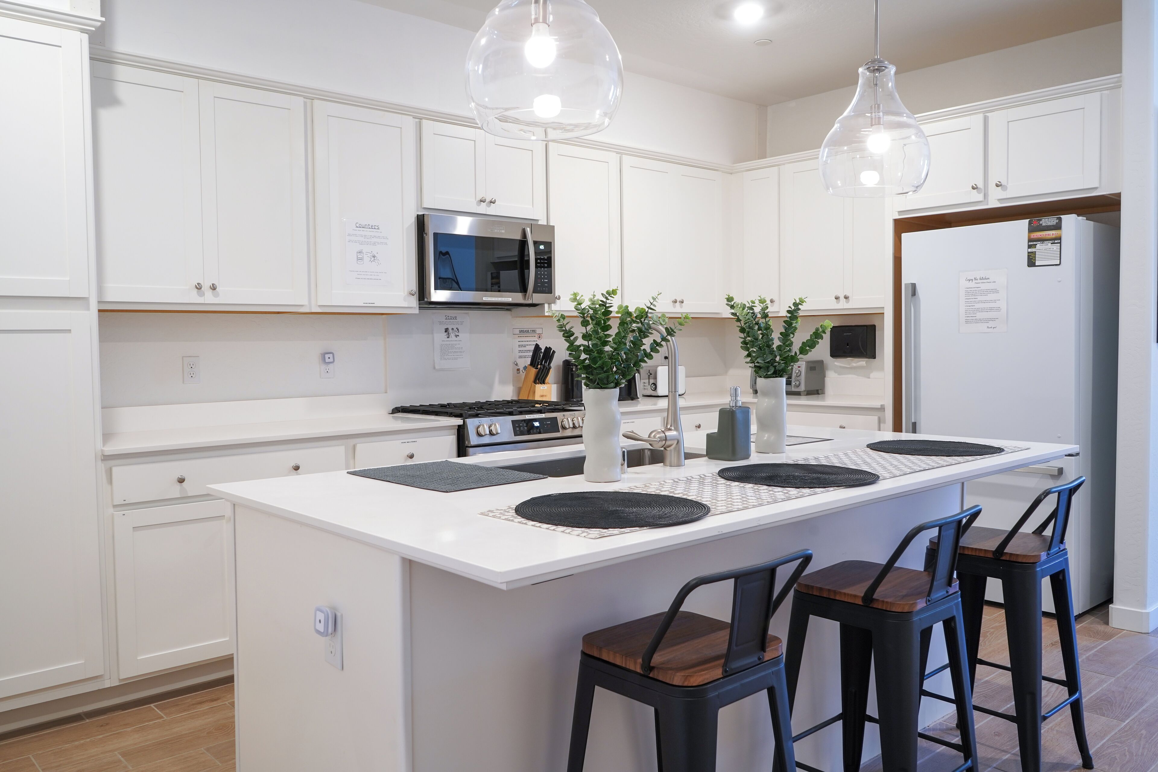 Newly renovated white kitchen with island and brown barstools, warm and inviting