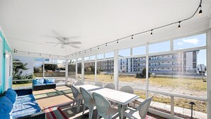 Aurinkoinen huone, jossa on ruokapöytä, tuoleja ja sohva.