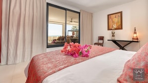 A hotel room with a bed, a desk, a chair, a window with a view, and a painting on the wall. - Montepulciano (Saint François)