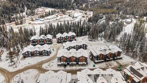 Un chalet doté de plusieurs cabanes, situé dans un cadre forestier enneigé.