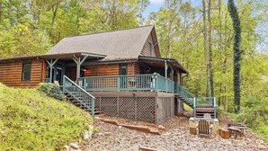 Een vakantiehuisje van hout met een veranda, houten terras en een trap naar de ingang.