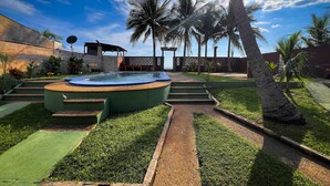 A swimming pool with steps leading into it, surrounded by palm trees and a clear sky. - Quinta Aqua Di Mar Playa Las Hojas (Playa Las Hojas)