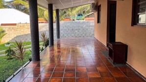 A covered outdoor area with tiled flooring, concrete pillars, and a brick wall. - Quinta Aqua Di Mar Playa Las Hojas (Playa Las Hojas)