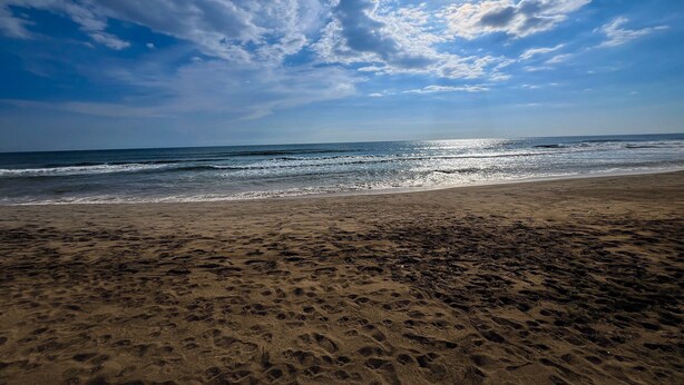 A beach with a clear sky and sunlight reflecting on the water. - Quinta Aqua Di Mar Playa Las Hojas (Playa Las Hojas)