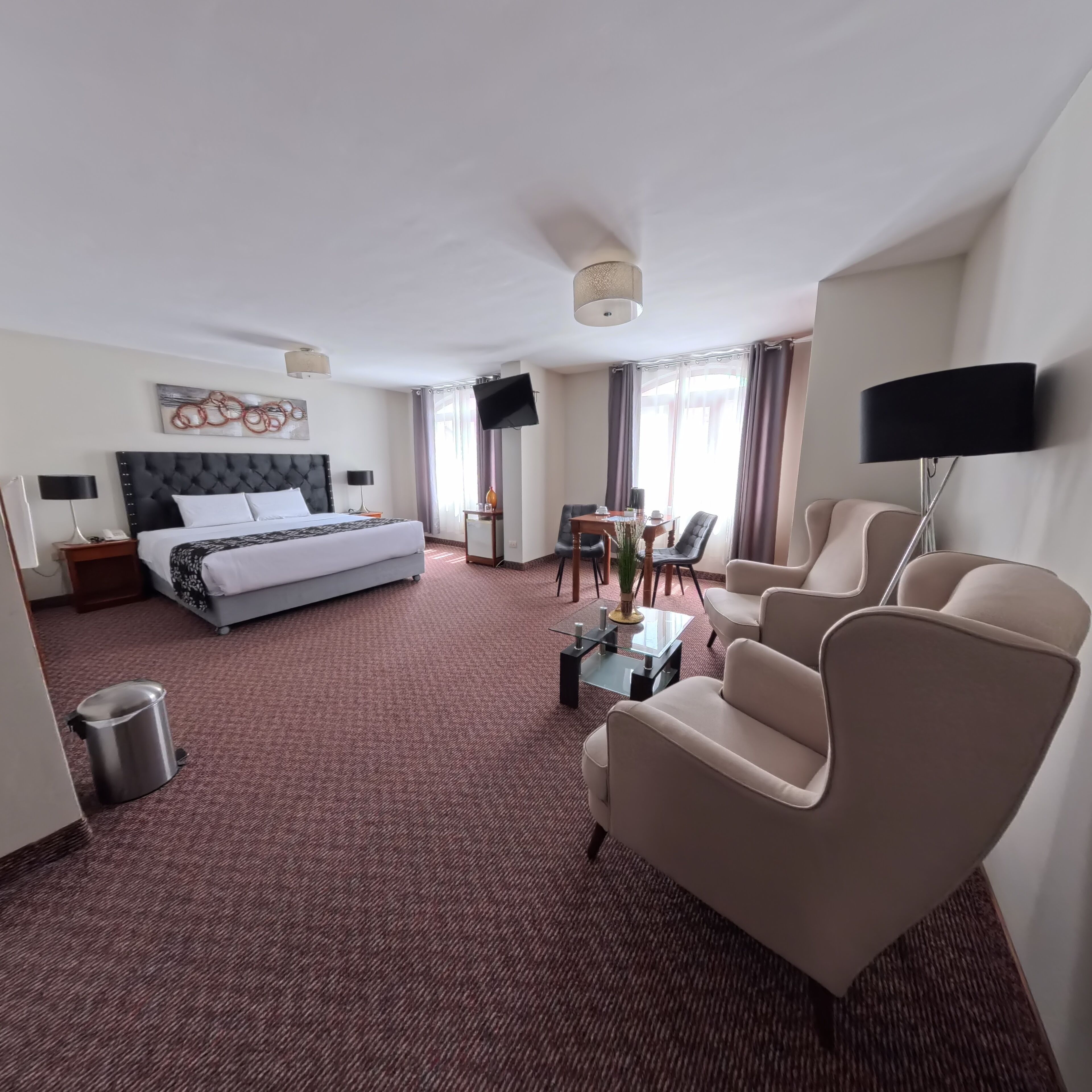 Une chambre d’hôtel équipée d’un lit, d’un bureau, d’une télévision et d’un coin salon.