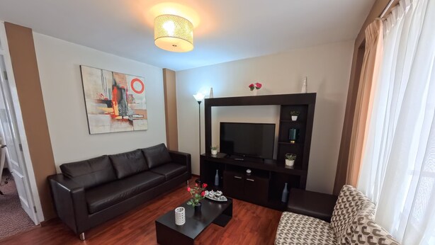 Ein modernes Wohnzimmer mit einer schwarzen Ledersofa, einem gemusterten Sofa und einem Couchtisch.