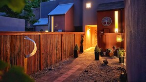 A modern outdoor area with a wooden fence, a pathway, and potted plants. - AirZen: Secure Gated 3BR Japandi Oasis w/ EV Garage, Trails & Views (Albuquerque)