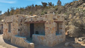 Un edificio de piedra con un pequeño porche y una puerta.