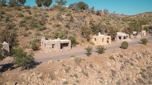 A rural landscape with stone buildings, a dirt road, and sparse vegetation. - The Hacienda - 4 Queen Beds (Truth or Consequences)