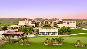 A golf academy with a large building, multiple tennis courts, and well-maintained lawns. - 4BR Ocean/Golf View • Pool & Transfers (Cabo San Lucas)