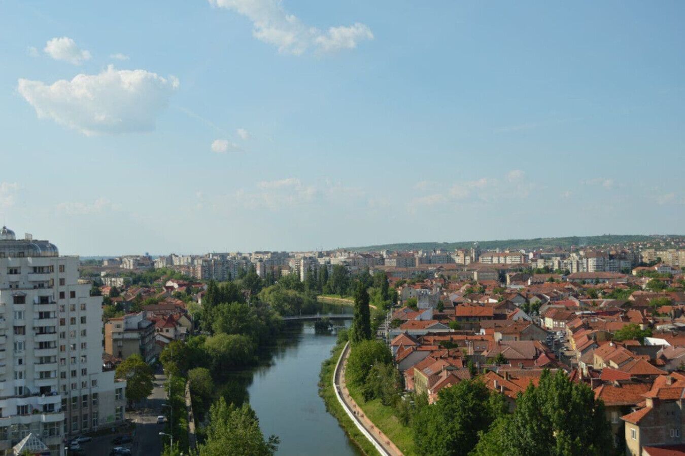 Ein Fluss fließt durch eine Stadt, gesäumt von modernen und traditionellen Gebäuden.