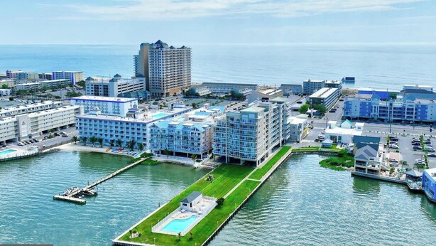 Un hotel sul lungomare con diversi edifici, un porto turistico e una grande piscina.