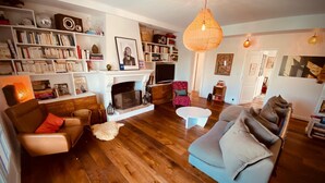 Una sala acogedora con chimenea, piso de madera y diferentes opciones de asientos.