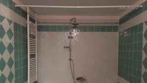 Ein Badezimmer mit Badewanne, Dusche und Handtuchhalter.