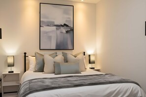 Escritorio, tabla de planchar con plancha, wifi y ropa de cama