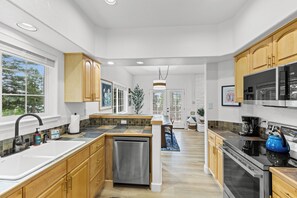 A modern kitchen with wooden cabinets, a dishwasher, a stove, and a sink. - Hawks Nest Dock & Beach Payette Lake McCall, Idaho (McCall)