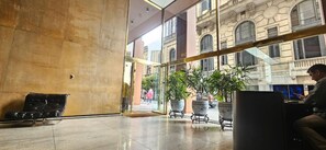 A spacious lobby with a high ceiling, large windows, and a seating area with a leather couch. - Beautiful apartment very close to Puerto Madero! Few meters from Florida Street, (BUENOS AIRES)