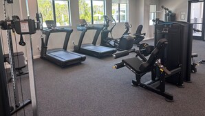 Una palestra con tapis roulant, macchinari ellittici e attrezzature per il sollevamento pesi.