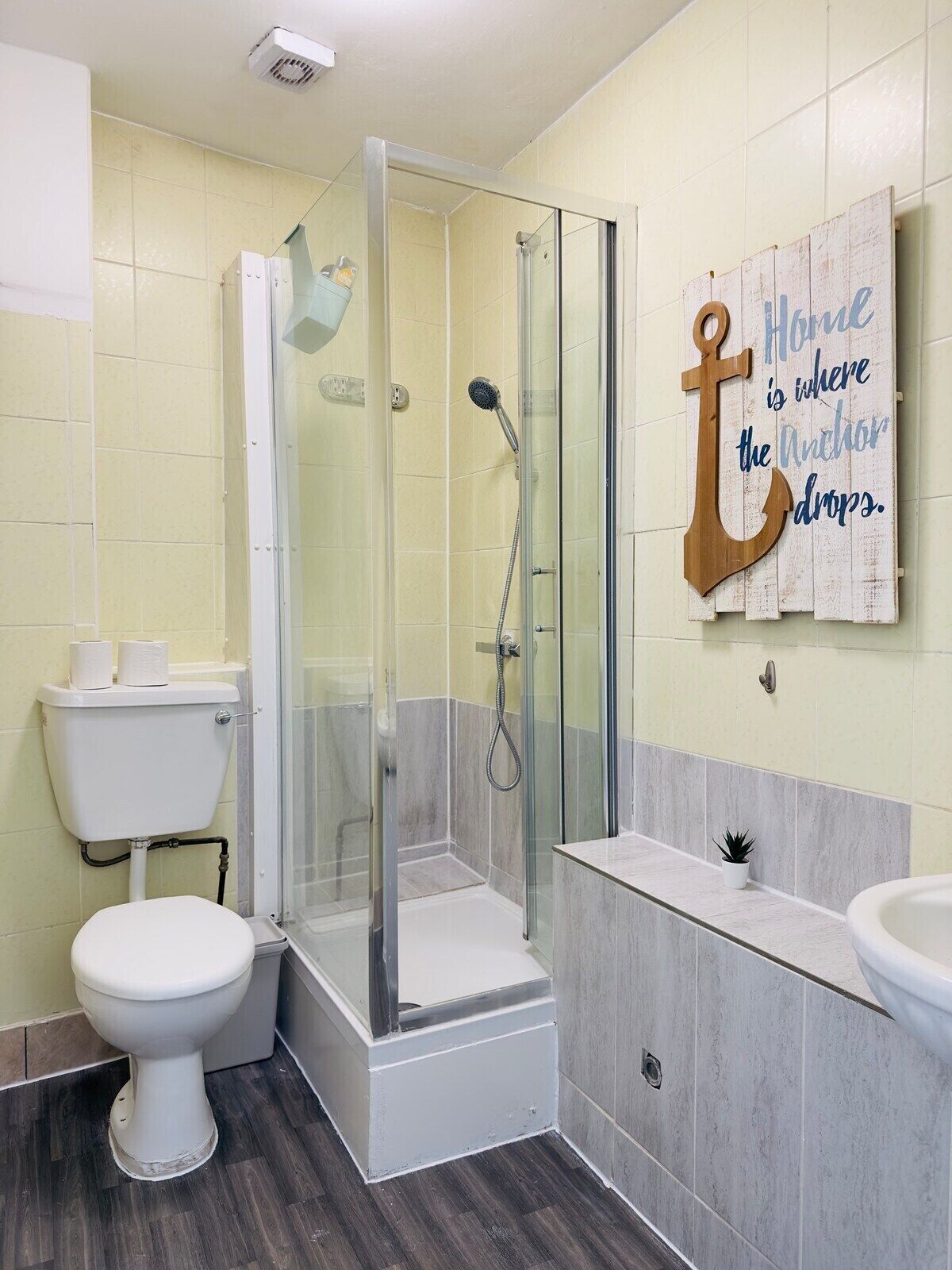 Une salle de bain avec une douche à parois de verre, des toilettes et un lavabo.