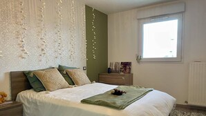 A bedroom with a bed, bedside tables, a dresser, and a window. - Proche du centre et plage, confort garanti (LA ROCHELLE)