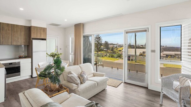 A modern apartment with a kitchen, living area, and balcony with a city view. - Little Blowhole Kiama, Garden Apartment (Kiama)