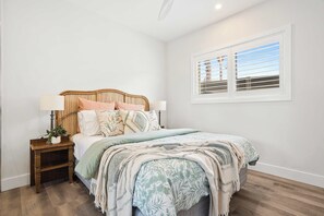 A bedroom with a bed, bedside tables, and a window. - Little Blowhole Kiama, Garden Apartment (Kiama)