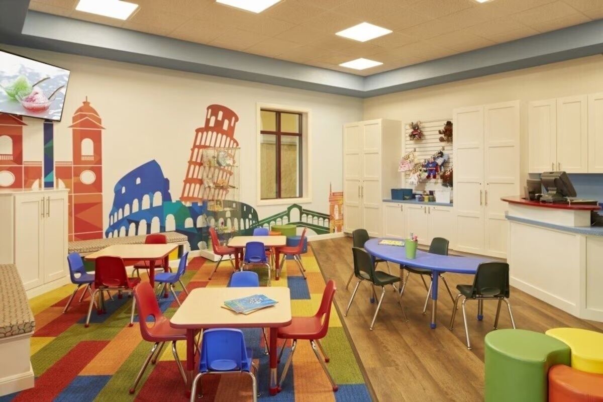 Ein Spielzimmer für Kinder mit farbigem Mobiliar und Wandgemälde bekannter Sehenswürdigkeiten.