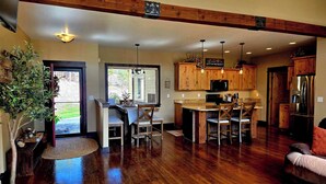 Una cocina amplia con armarios de madera, una isla central y un comedor con sillas.