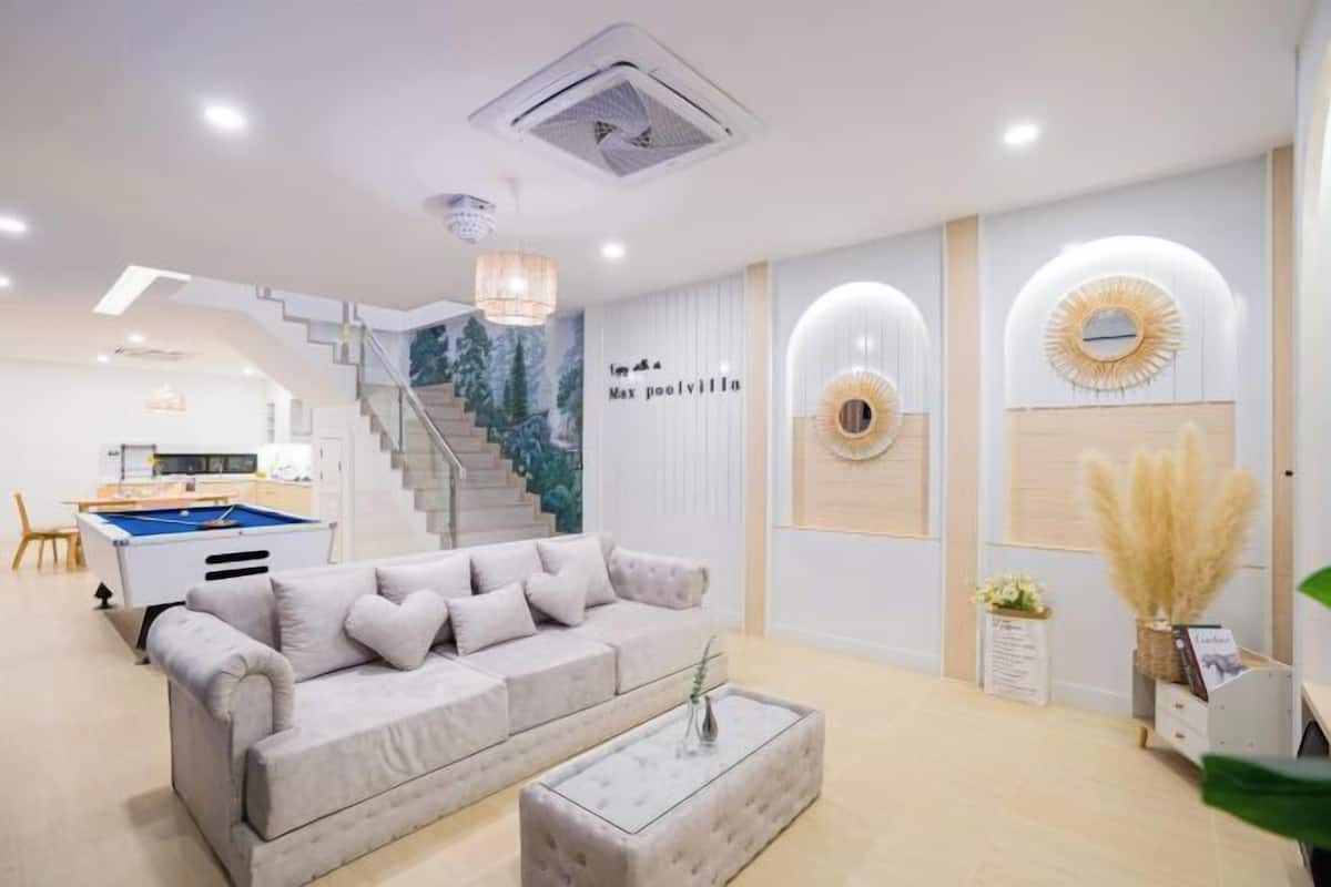 A modern living room with a sofa, coffee table, and a staircase leading to an upper level.