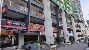 A multi-story building with commercial establishments on the ground floor, including a Pizza Hut and a Kapitan restaurant. - Setia Tri-Suite(3) by Homey Planet (Bayan Lepas)