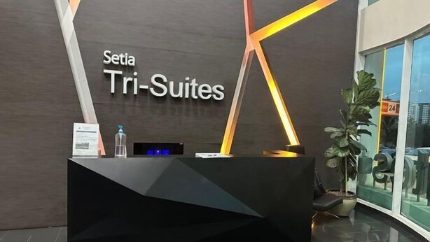 A reception desk with a modern design, featuring the name "Setia Tri-Suites" prominently displayed. - Setia Tri-Suite(3) by Homey Planet (Bayan Lepas)