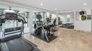 Un gimnasio moderno con cintas de correr, elípticas y bancos de pesas.