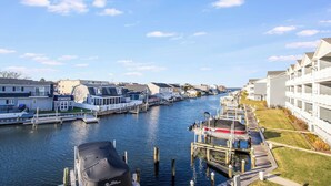 A marina with boats docked, a clear sky, and waterfront buildings. - Harbour Club A5 (Ocean City)