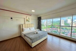 Una camera da letto con una grande finestra, un letto e vista sugli edifici.