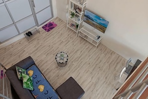 A room with a sofa, a coffee table, a bookshelf, and a painting on the wall. - The CEO Suite9 By Homey Planet (Bayan Lepas)