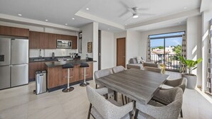 A modern kitchen with a dining area, a large window with a view, and a ceiling fan. - Galeritas 5 | 2BR/2BA in Puerto Vallarta w/ pool (Puerto Vallarta)