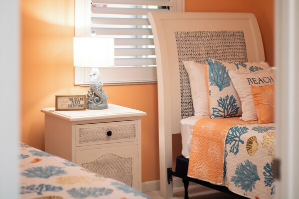 Une chambre à coucher avec un lit, une table de chevet et un petit objet décoratif posé sur la table de chevet.