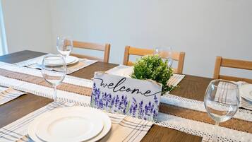 A dining table set with plates, glasses, and a 'welcome' sign with lavender flowers.