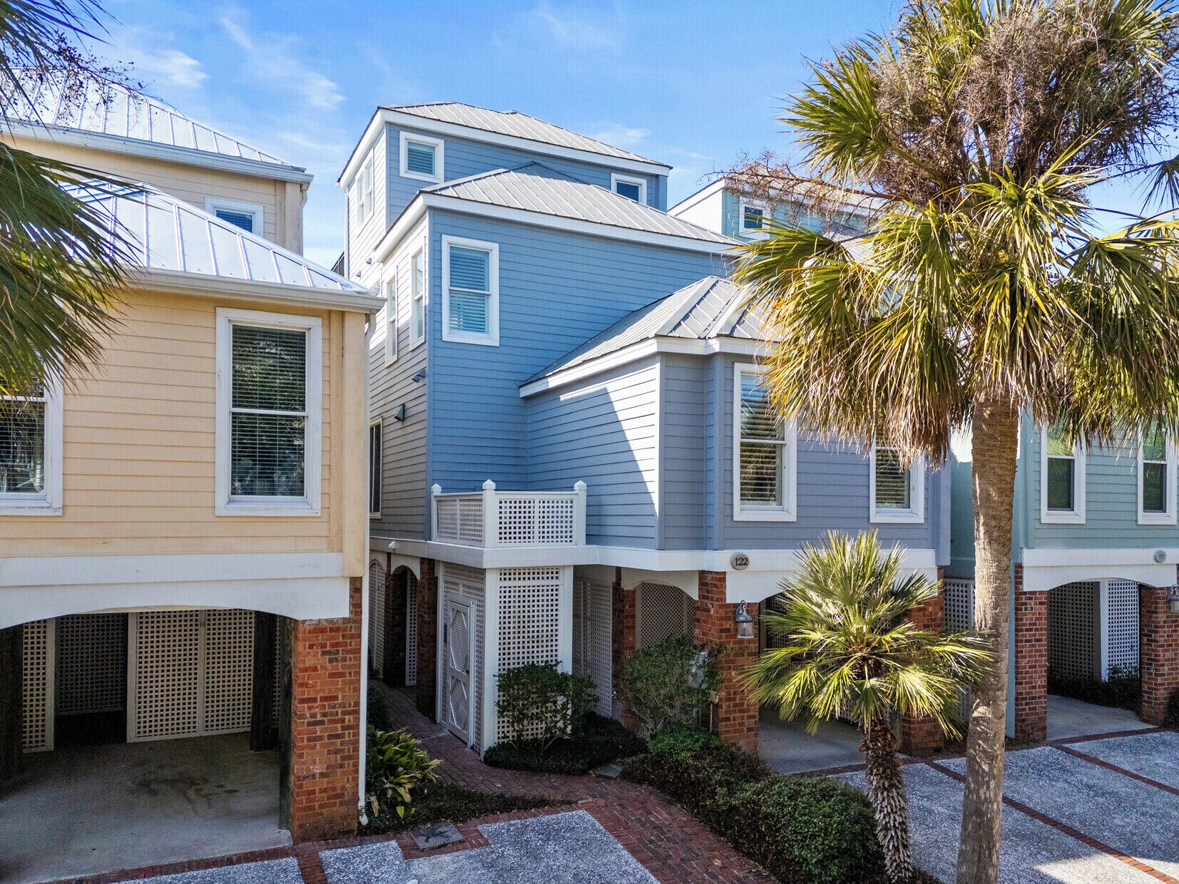 A row of coastal-style houses with a brick foundation and white railings.