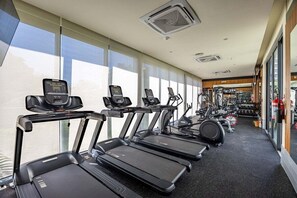 Ein Fitnessstudio mit Laufbändern, Crosstrainern und Gewichtsgeräten.
