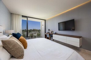 Ein modernes Hotelzimmer mit einem großen Bett, einem Schreibtisch und einem Fernseher.