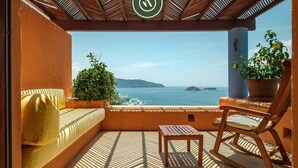 A balcony with a view of the sea, a wooden chair, a small table, and a potted plant. - 4 BR Penthouse - Breathtaking Views - Private Pool (Zihuatanejo)