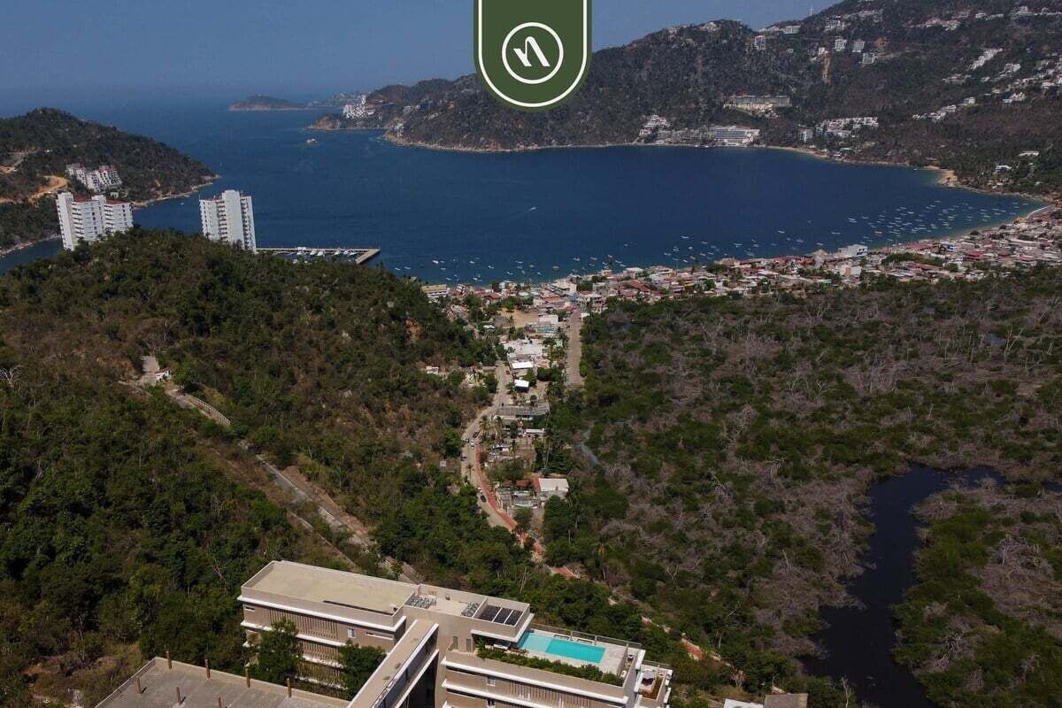 A coastal town with a view of the sea, buildings, and a swimming pool.