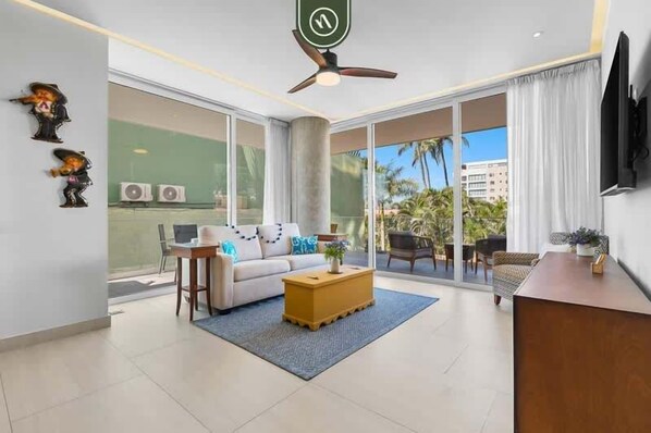 Una sala de estar moderna con un sofá, una mesa de centro y un televisor sobre un mueble.