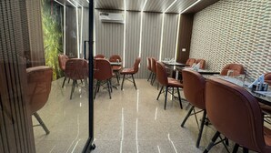 A modern conference room with glass walls, leather chairs, and a patterned wall. - Hotel Natraj A Boutique Hotel (Haridwar)