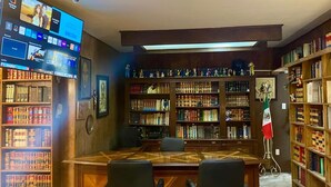 Eine Bibliothek mit Bücherregalen, einem Schreibtisch und Stühlen.